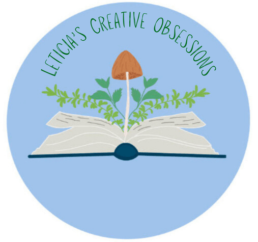 A powder blue circular graphic with an illustration of an open book, rosemary, mint and a brown mushroom growing from the pages and "Leticia's Creative Obsessions" in green ink above. 