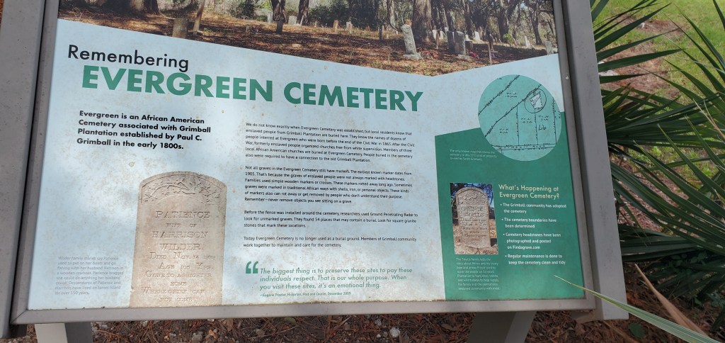 A placard with information about Evergreen Cemetery in Charleston, South Carolina. Some of the visible text reads, "Remembering Evergreen Cemetary. Evergreen is an African American Cemetery associated with Grimball Plantation established by Paul C. Grimball in the early 1800s." 