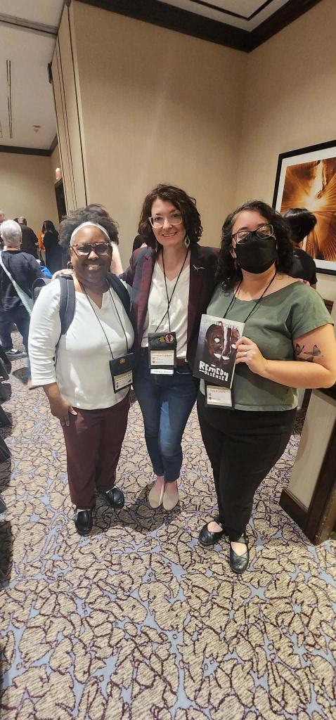 Nicole Givens Kurtz, Rebecca Cutherbet and Leticia Urieta posing together in a hotel conference room.