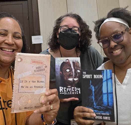L. Marie Wood, Leticia Urieta and Nicoe Givens Kurtz holding up their books to the camera and posing side by side.